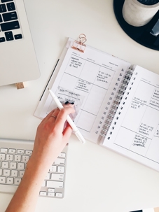 Work schedule and planner on white background and surrounded by items (laptop, keyboard, mouse) on desk